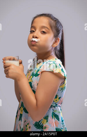 Seitenansicht eines Mädchens mit Milch Schnurrbart trinken Milch in ein Glas Stockfoto