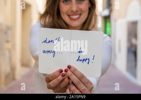 Portrait von lächelnden Frau, holding Notizbuch: sorgen Sie sich nicht glücklich sein! Stockfoto