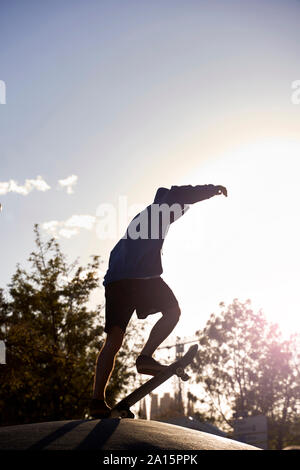 Die Silhouette eines jungen Skateboarding bei Sonnenuntergang in Barcelona, Spanien Stockfoto