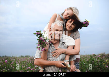 Porträt der kleinen Mädchen und ihre Großeltern mit gepflückten Blumen in der Natur Stockfoto