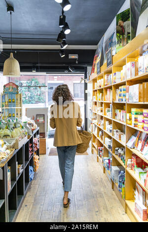 Junge Frau Shopping in einem Lebensmittel Shop Stockfoto