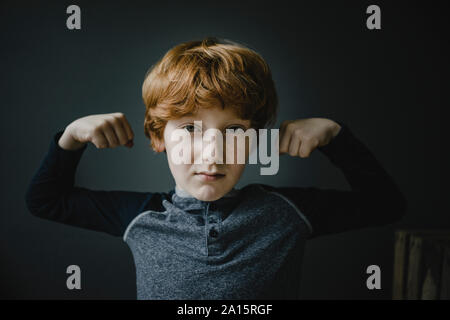 Portrait von rothaarigen Jungen flexing Muskeln Stockfoto