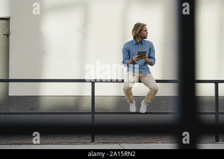 Junger Mann mit Tablet in der Stadt umher, um die Stockfoto