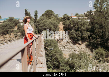 Portrait von lächelnden jungen Mädchen mit Strohhut, stehend auf einer Brücke Stockfoto