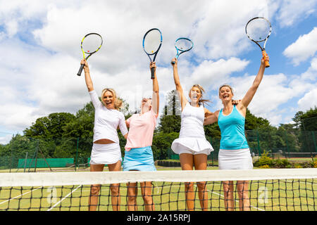 Gerne weiblich Tennis Spieler feiern den Sieg auf dem Rasen Hof Stockfoto