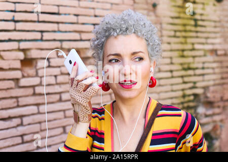 Portrait von durchbohrt, reife Frau am Telefon Stockfoto