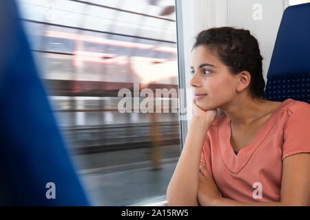 Teenage Mädchen allein mit dem Zug reisen, suchen Sie im Fenster Stockfoto