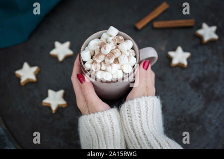 Woman's Hände, die Tasse heiße Schokolade mit Marshmallows an Weihnachten Stockfoto