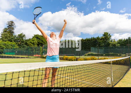 Gerne weiblich Tennis Spieler feiern den Sieg auf dem Rasen Hof Stockfoto