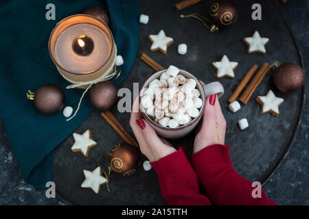 Woman's Hände, die Tasse heiße Schokolade mit Marshmallows an Weihnachten Stockfoto