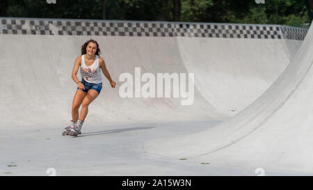 Junge Frau Inline Skating im Skatepark Stockfoto