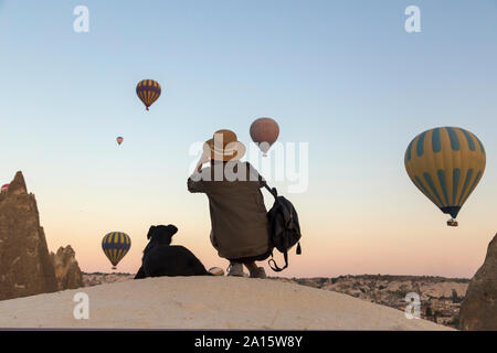 Junge Frau und Heißluft-ballons, Göreme, Kappadokien, Türkei Stockfoto