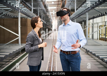 Geschäftsfrau im Gespräch mit Unternehmer tragen VR-Brille in der Factory Stockfoto