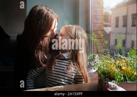 Lächelnde Mädchen mit ihrer Mutter in ein Cafe Stockfoto