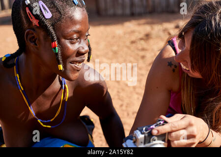 Weiße Frau, ein Bild auf Ihrer Kamera zu einem Mudimba Stamm Frau, Canhimei, Angola Stockfoto
