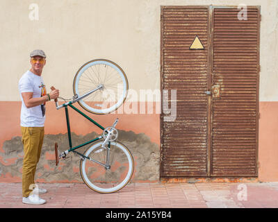 Mann mit Fixie bike stand vor einer Wand Stockfoto