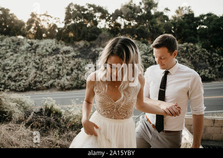 Liebevolle Braut und Bräutigam, Hände halten im Freien Stockfoto