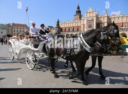 Krakau. Krakau. Polen. Die Kutsche der Kabine auf dem Hauptmarkt mit Touristen. Stockfoto