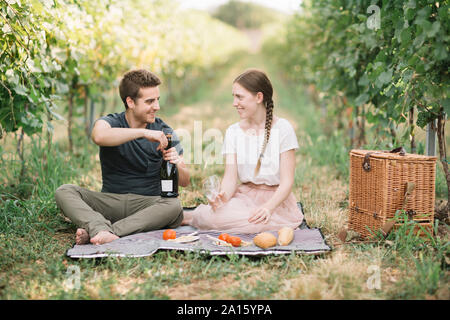 Glückliches junges Paar mit Picknick in den Weinbergen Stockfoto