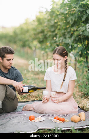 Glückliches junges Paar in Picknick mit Prosecco in den Weinbergen Stockfoto