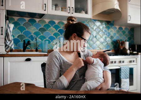 Porträt einer jungen Frau mit einem Baby zu Hause Stockfoto