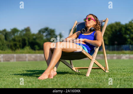 Junge Frau beim Sonnenbaden auf Rasen Stockfoto