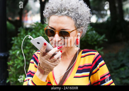 Portrait von durchbohrt, reife Frau mit Smartphone im Freien Stockfoto