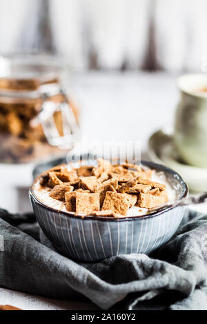 Nahaufnahme der frische, hausgemachte gebackene Zimt Müsli mit Joghurt in Schale auf der Serviette Stockfoto