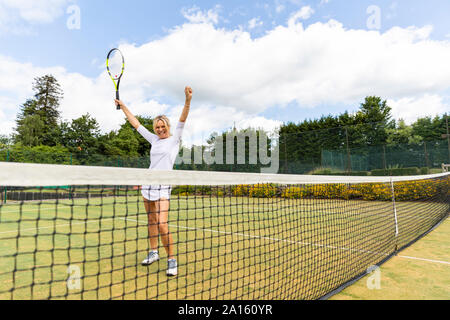 Gerne weiblich Tennis Spieler feiern den Sieg auf dem Rasen Hof Stockfoto