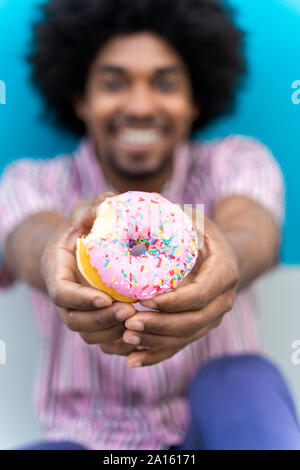 Junger Mann Essen donut Stockfoto