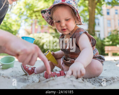 Portrait von Mädchen mit ihrer Mutter im Sandkasten auf dem Spielplatz Stockfoto