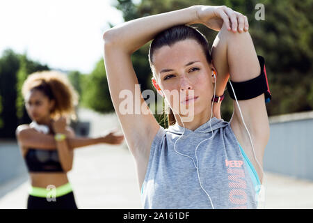 Zwei sportliche junge Frauen tun stretching Übung Stockfoto