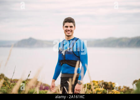 Portrait von lächelnden Trail Runner stehend in die Berge, Ferrol, Spanien Stockfoto