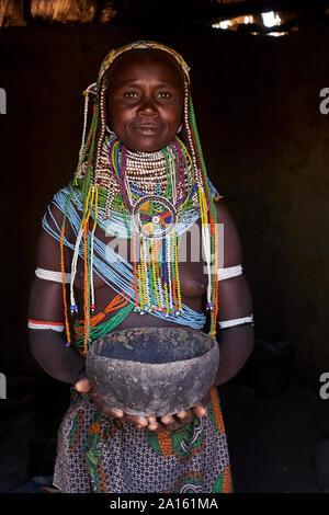 Porträt einer Muhila traditionelle Frau, die in ihrem Haus, halten Topf, Congolo, Angola Stockfoto
