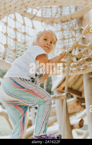 Mädchen klettern in Jungle Gym auf einem Spielplatz Stockfoto