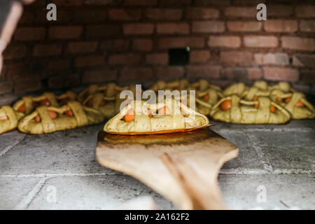 Close-up von Mona de Pascua auf Pizza Peel im Holzofen Stockfoto