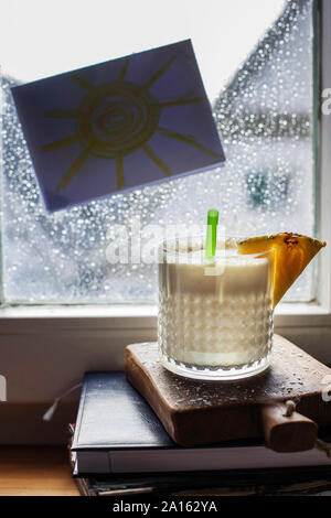 Glas Pina Colada stand vor der Fenster in die Regentropfen fallen Stockfoto