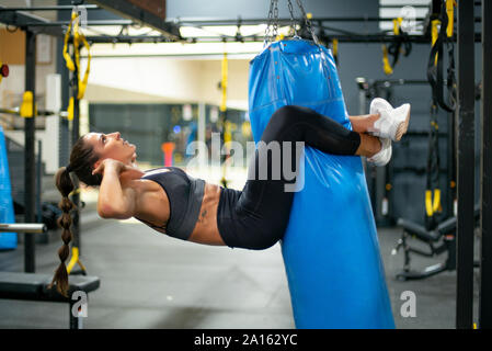 Junge Frau Training am Boxsack in der Turnhalle Stockfoto