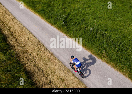 Triathlet Reiten Fahrrad auf Landstraße, Deutschland Stockfoto