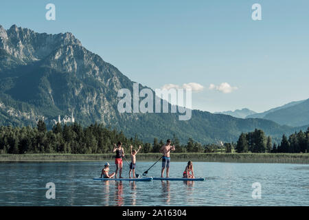 Familie mit Stand up Paddle Boards auf einem See, Bannwaldsee, Allgäu, Bayern, Deutschland Stockfoto