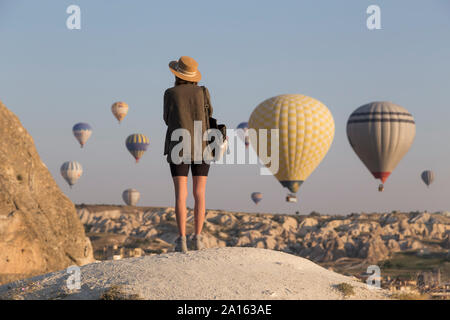 Junge Frau und Heißluft-ballons, Göreme, Kappadokien, Türkei Stockfoto