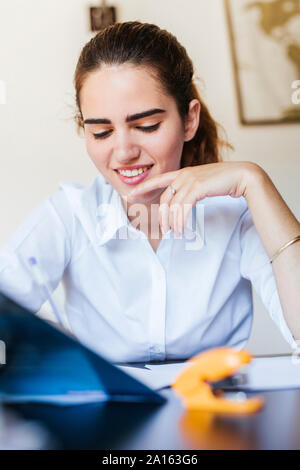 Lächelnd weibliche Schüler lernen am Schreibtisch zu Hause Stockfoto