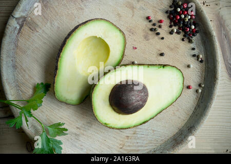 Halbierte Avocado, Petersilie und Pfeffer von oben gesehen Stockfoto