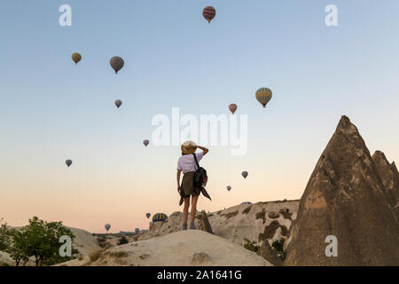 Junge Frau und Heißluft-ballons, Göreme, Kappadokien, Türkei Stockfoto