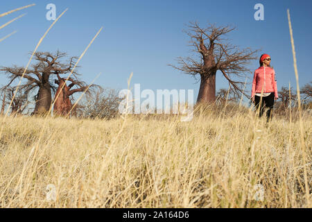 Frau mit Baobab Bäume im Hintergrund, Makgadikgadi Pans, Botswana Stockfoto