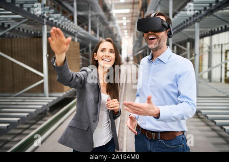 Happy Unternehmerin und Unternehmer tragen VR-Brille in der Factory Stockfoto