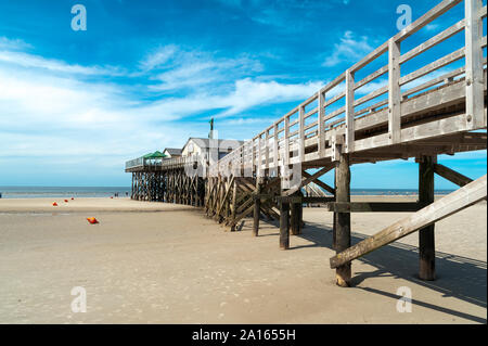 Deutschland, Schleswig-Holstein, Sankt Peter-Ording, Strand mit Brücke und Pfahlbauten bei Ebbe Stockfoto