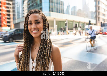 Portrait von lächelnden jungen Frau in der Stadt, London, UK Stockfoto