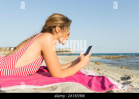 Junge Frau Sie ihr Smartphone am Strand Stockfoto