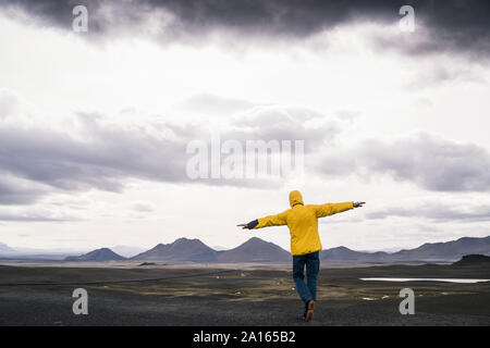 Reifen Mann, der mit den Armen in das Hochland von Island Stockfoto